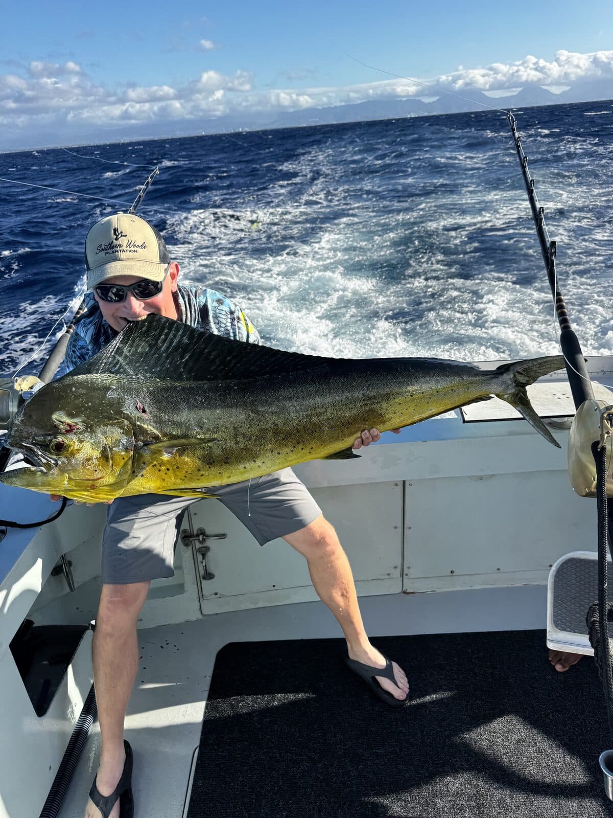 An angler holding a big bull mahimahi
