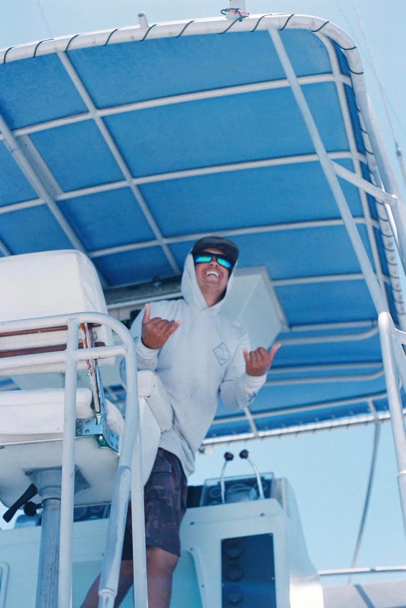 Capt. Gabe Duran laughing and throwing shakas under the tuna tower of Ruckus