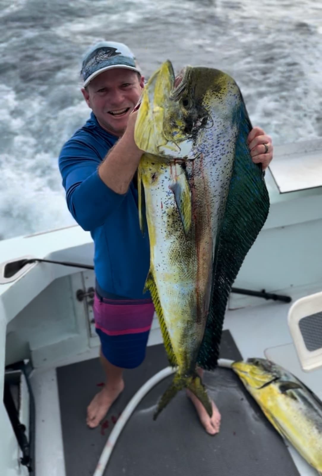 Second mate Mike Marks holding up a bull mahimahi aboard Ruckus