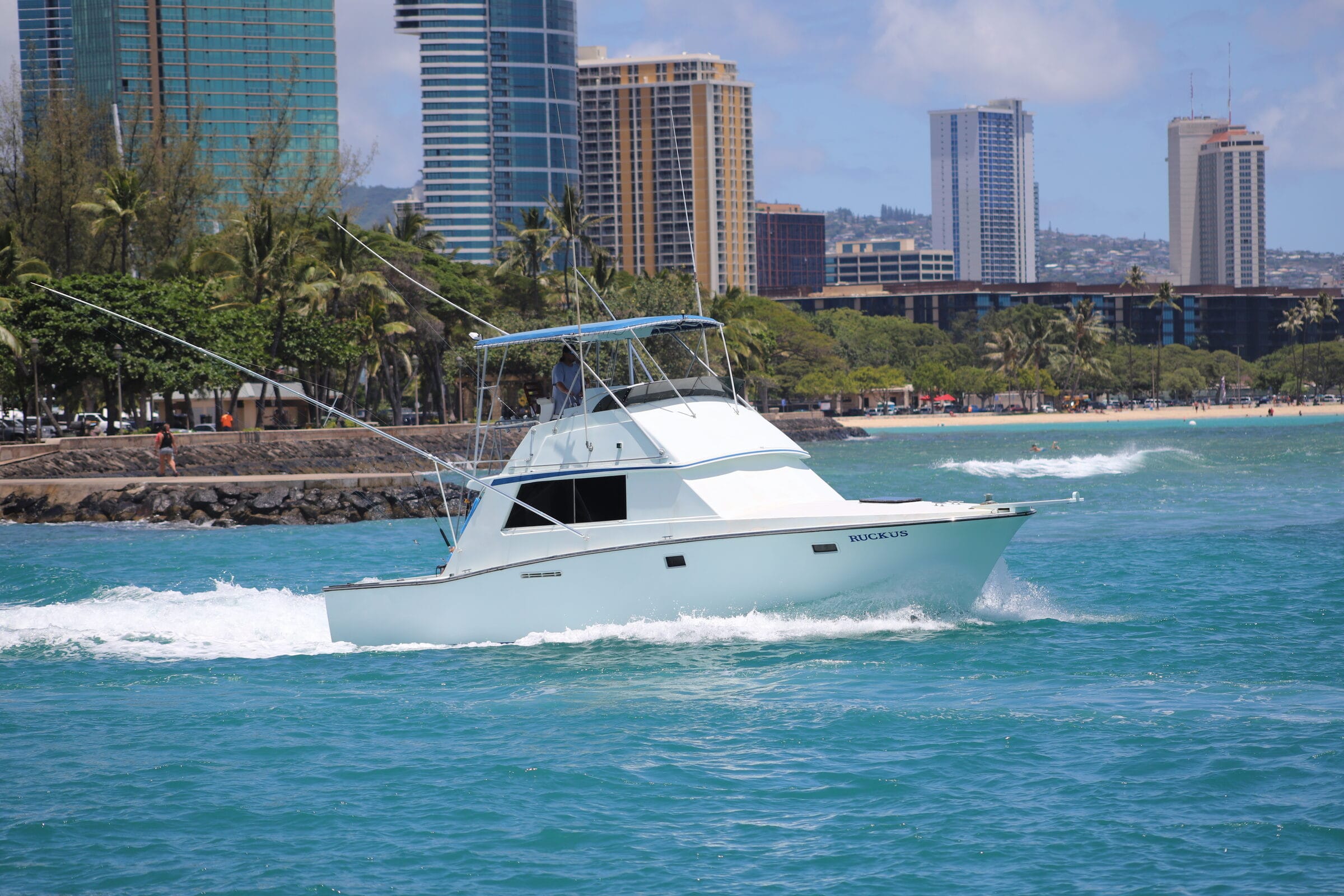 Ruckus running out of Kewalo Basin with the Honolulu skyline behind her